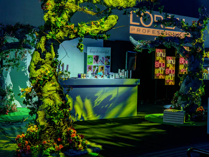 A stand framed by an arch of greenery at L’Oréal Montreal Unplugged 2019