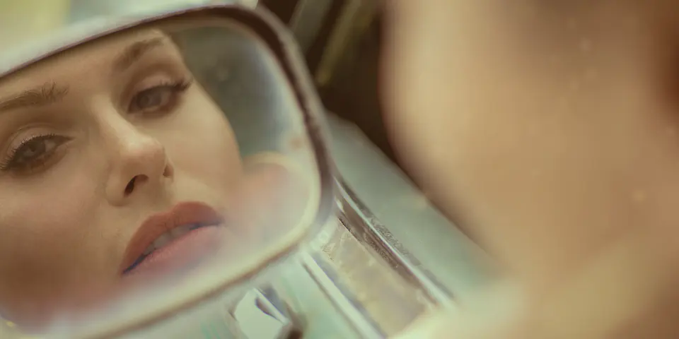 Joby Bach’s face in the side mirror of a vintage car, from the story Stranded